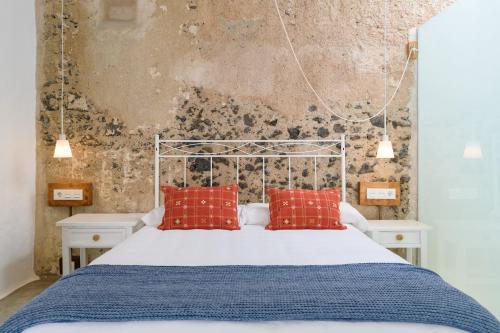 ein Schlafzimmer mit einem Bett mit roten Kissen in der Unterkunft Casa el Alto - Lava in Punta de Mujeres