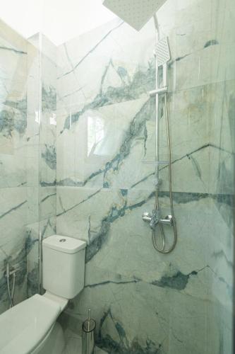 a bathroom with a white toilet and a shower at Voyage Villa in Vlorë