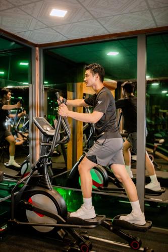 a man sitting on a treadmill in a gym at Resort Hàng Dương in Blao Klong Ner