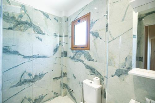 a bathroom with a toilet and a window at Voyage Villa in Vlorë
