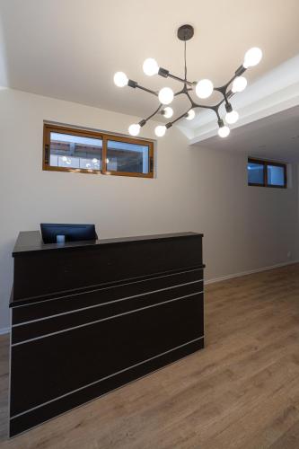 a room with a black desk and a chandelier at Voyage Villa in Vlorë