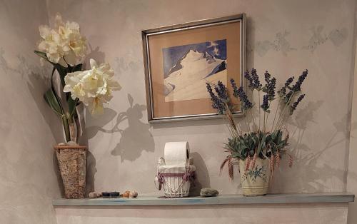 a shelf with vases and flowers on a wall at Apartma Antico in Kranjska Gora