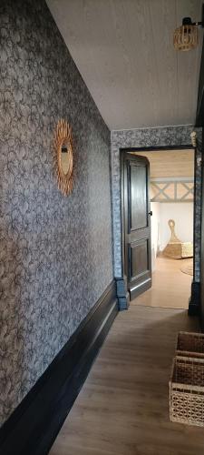 a hallway with a wall with a mirror and a door at La Costa Bella in Libourne