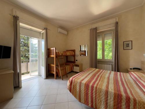a bedroom with a bed and a window and a chair at Hotel Villa Robinia in Genzano di Roma