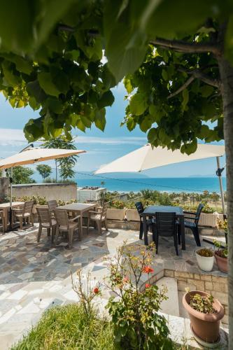 a patio with tables and chairs and umbrellas at Voyage Villa in Vlorë