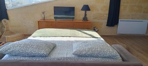 a bedroom with a bed and a television on a dresser at La Costa Bella in Libourne