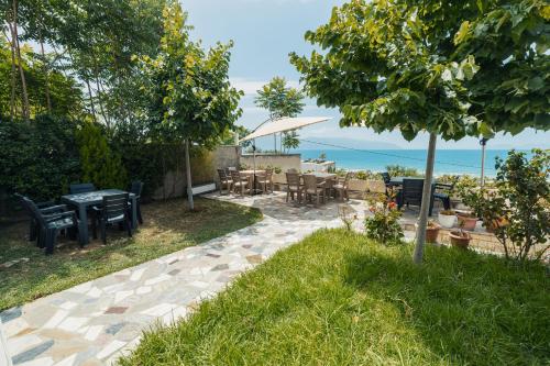 a patio with a table and chairs and the ocean at Voyage Villa in Vlorë