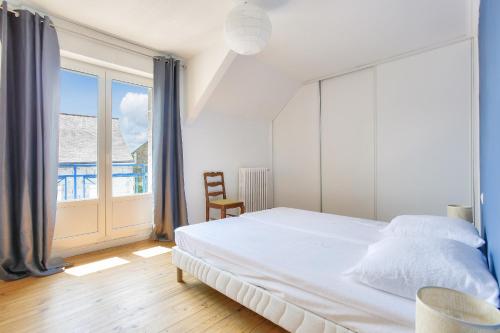 une chambre avec un lit et une grande fenêtre dans l'établissement Maison pour 6 au calme - A moins de 2km de la plage, à Dinard