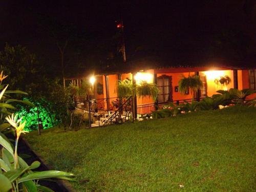 a house with lights in a yard at night at Hotel Campestre la Navarra in La Suiza