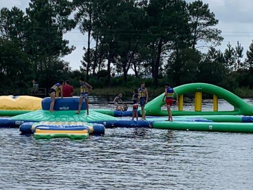 un groupe de personnes debout sur un radeau gonflable dans l'eau dans l'établissement 250 lake waterfront holiday apartment with garden, à Hourtin