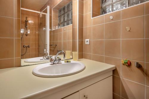 une salle de bain avec un lavabo et un miroir dans l'établissement La Baule, 30m de la plage et proche tous commerces, à La Baule