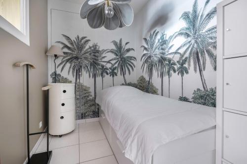 - une chambre avec des palmiers sur le mur dans l'établissement La Baule, 30m de la plage et proche tous commerces, à La Baule