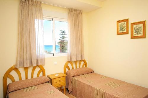 a hotel room with two beds and a window at Apartamento Belvedere - Deniasol in Denia