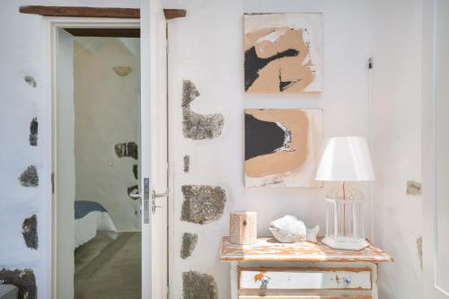 a room with a table with a lamp and paintings on the wall at Casa el Alto - Picon in Punta de Mujeres