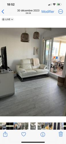 un salon avec un canapé blanc et une télévision dans l'établissement Cosystcyp, à Saint-Cyprien