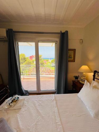 a bedroom with a large bed and a window at Lefkada Beach Villa in Lefkada