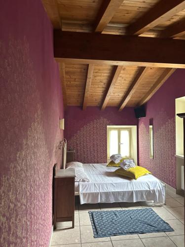 a bedroom with a purple wall with a bed in it at Relais San Michele in Rivoli Veronese