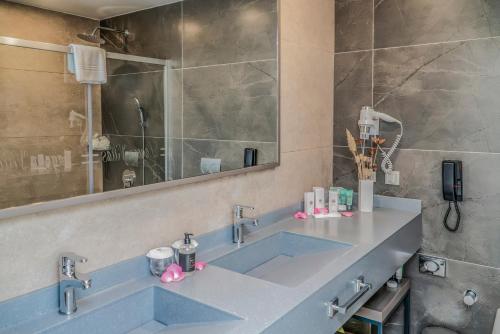 a bathroom with a blue sink and a mirror at Royal Wings Hotel in Lara