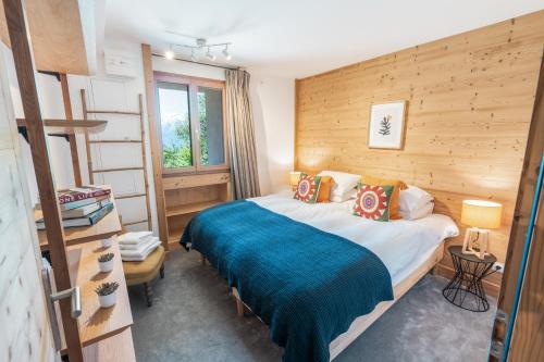 une chambre avec un lit avec une couverture bleue dans l'établissement Chalet Galbert, Vaujany, à Vaujany