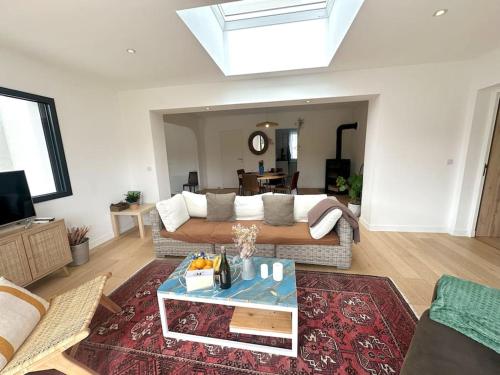 a living room with a couch and a table at Grande Maison - Proche plages - Combrit Ste Marine in Combrit
