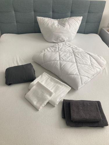 a bed with white sheets and pillows on it at App 8u Heimatliebe in Dranske