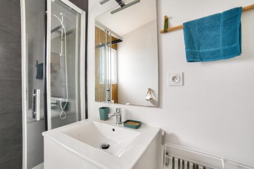 a white bathroom with a sink and a mirror at 180m de la plage, quartier animé studio 2 personnes in La Tranche-sur-Mer