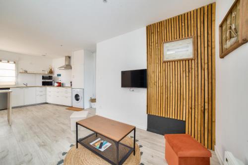 un salon avec une table et une cuisine dans l'établissement 180m de la plage, quartier animé studio 2 personnes, à La Tranche-sur-Mer