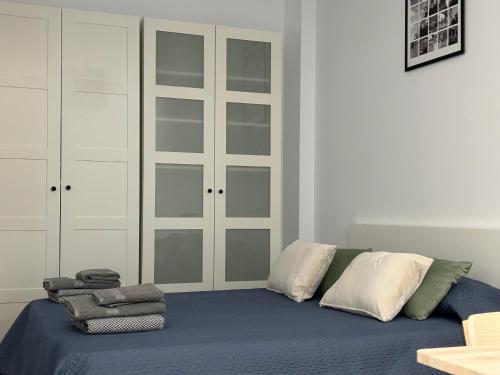 a bedroom with a blue bed with white cabinets at AZCA-Bernabéu Apartments in Madrid