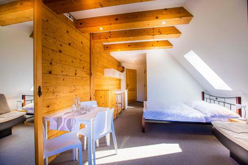 a room with a table and a bed and a bedroom at Holiday Home Holiday Raj in Bešeňová