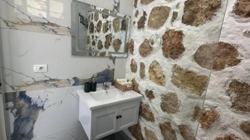 bagno con lavandino e parete in pietra di Firauni Studios a Vlorë