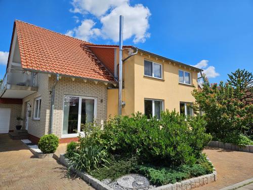 a house with an orange roof and some bushes at 3 Sterne FeWo Gold-Blick Urlaub zwischen Edersee und Willingen in Korbach