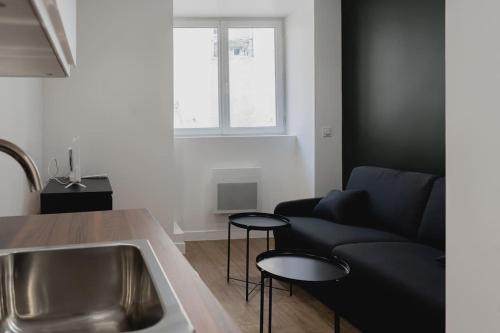 - un salon avec un canapé, une table et un lavabo dans l'établissement Studio Gorgeat, à Chambéry