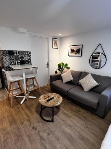 un salon avec un canapé et une table dans l'établissement Studio proche gare et Versailles 4 min à pied train vers Paris, à Marly-le-Roi