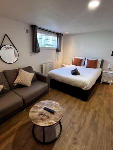 une chambre d'hôtel avec un lit et un canapé dans l'établissement Studio proche gare et Versailles 4 min à pied train vers Paris, à Marly-le-Roi