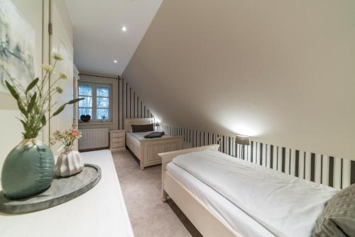 a bedroom with a bed and a table with flowers at Apartmenthaus Haus Sonne I direkt am Strand in Dierhagen