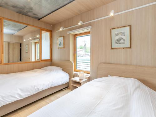 a bedroom with two beds and a mirror at Tabist Kaihorow Otaru in Otaru