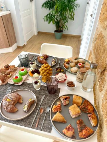ein Tisch mit Tellern voller Essen auf einem Tisch in der Unterkunft Nike Luxury Rooms in Agrigento