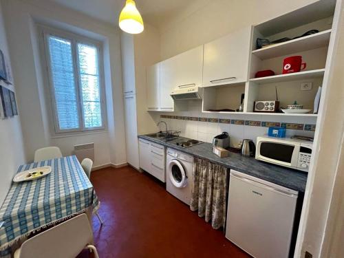 Il comprend une cuisine équipée d'une table, d'une cuisinière et d'un four micro-ondes. dans l'établissement A004 - Bright apt Rue d'Antibes at 300m from beach Croisette, à Cannes