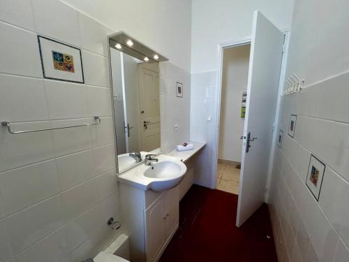 une salle de bain blanche avec un lavabo et un miroir dans l'établissement A004 - Bright apt Rue d'Antibes at 300m from beach Croisette, à Cannes