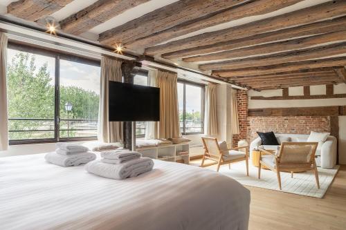 une chambre avec un grand lit avec une télévision à écran plat dans l'établissement Pick A Flat's Apartments in Saint Louis - Quai des Orfèvres, à Paris