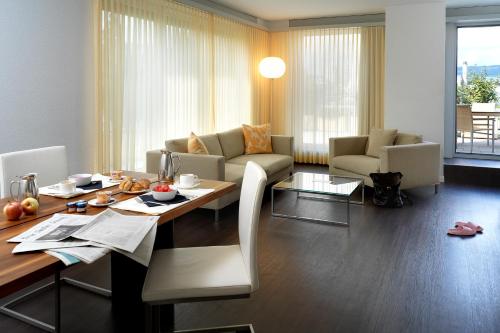 a living room with a table and a living room with a couch at Park Hotel Zug in Zug