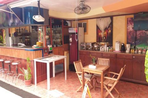 a restaurant with a table and chairs and a counter at Citadel Bed and Breakfast in Puerto Princesa City
