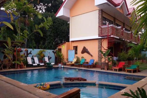 a swimming pool in front of a building at Citadel Bed and Breakfast in Puerto Princesa City