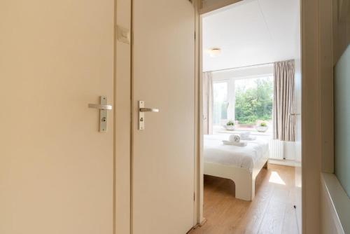 a bedroom with a bed and a window at Hello Zeeland - vakantiewoning Buiten de Veste 36 in Veere