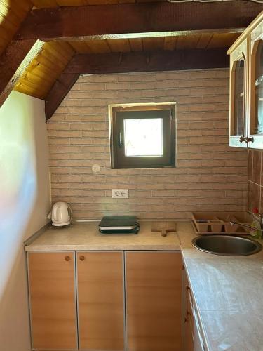 a kitchen counter with a sink and a window at Bungalows Krstajić in Žabljak