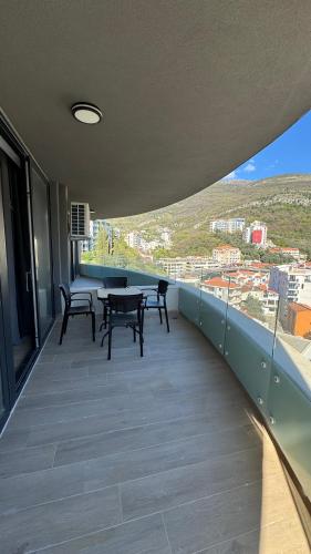 a balcony with tables and chairs on top of a building at Jadran Dream2 in Rafailovici