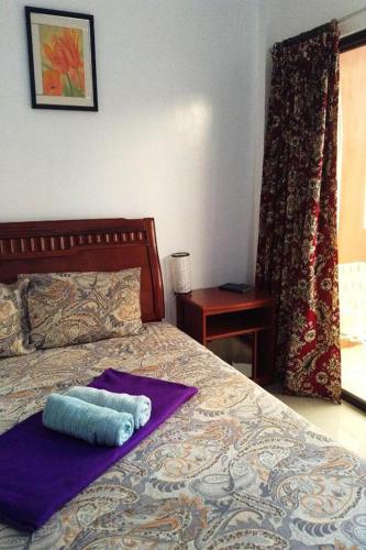 a bedroom with a bed with a towel on it at Citadel Bed and Breakfast in Puerto Princesa City