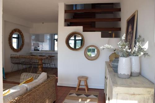 a living room with a couch and mirrors at Casa da Praia em Soltroia Mar in Comporta