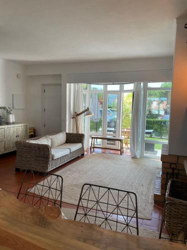 a living room with a couch and a large window at Casa da Praia em Soltroia Mar in Comporta