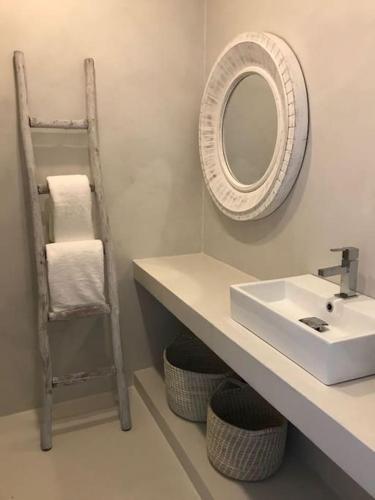 a bathroom with a sink and a mirror and a ladder at Casa da Praia em Soltroia Mar in Comporta